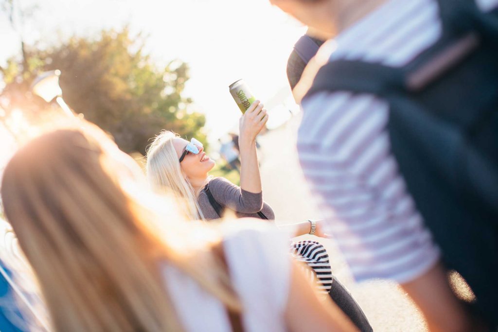 Frau im Sommer mit einer Weinschorle in der Hand