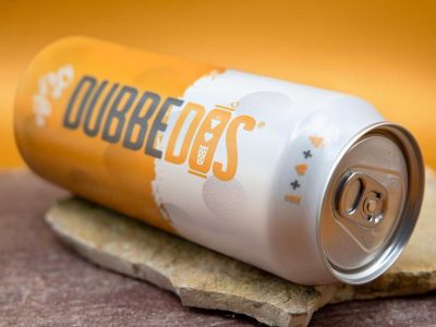 Liegende Dose der DUBBEDOS Süßen Weinschorle auf einem Stein, zeigt das ikonische Design und die geöffnete Dosenoberseite.